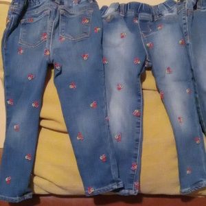 Childrens Gap blue denim jeggings with pink, yellow and red floral embroidery.